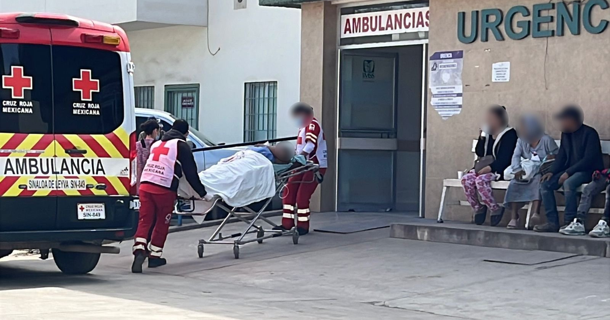 Paramédicos de la Cruz Roja Mexicana llevan en camilla a un paciente herido de bala fuera de un hospital.