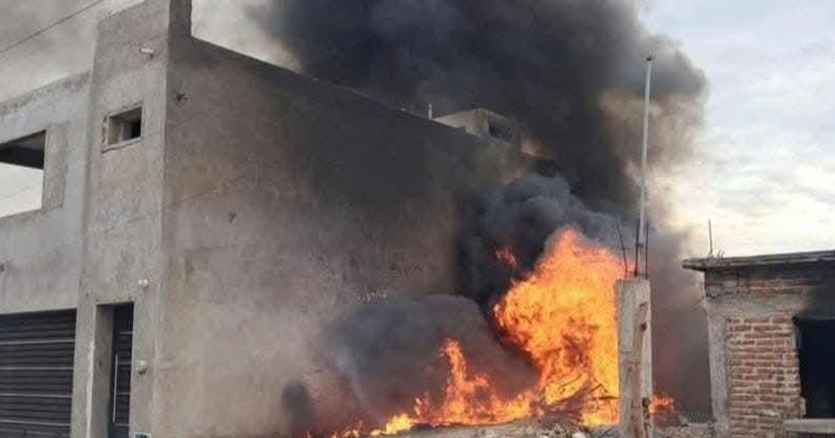 Edificio en llamas con humo negro en Los Mochis, evidenciando el incendio en un vertedero clandestino.