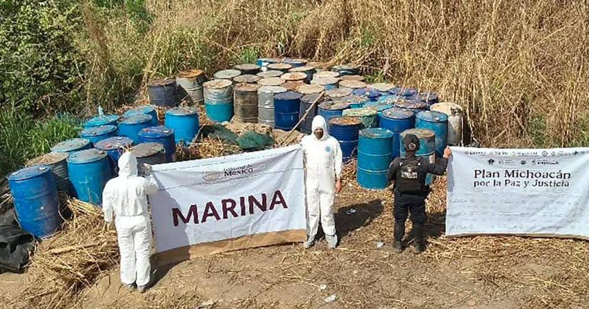 Operativo de la Marina en laboratorios clandestinos, con personal en trajes de seguridad y pancartas en un entorno al aire libre.