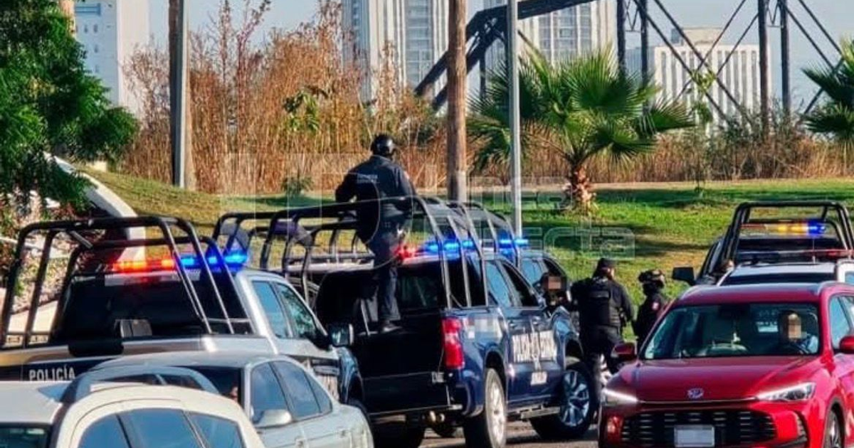 Escena de intervención policial con vehículos y agentes en Culiacán, relacionada con la desaparición de un policía municipal.