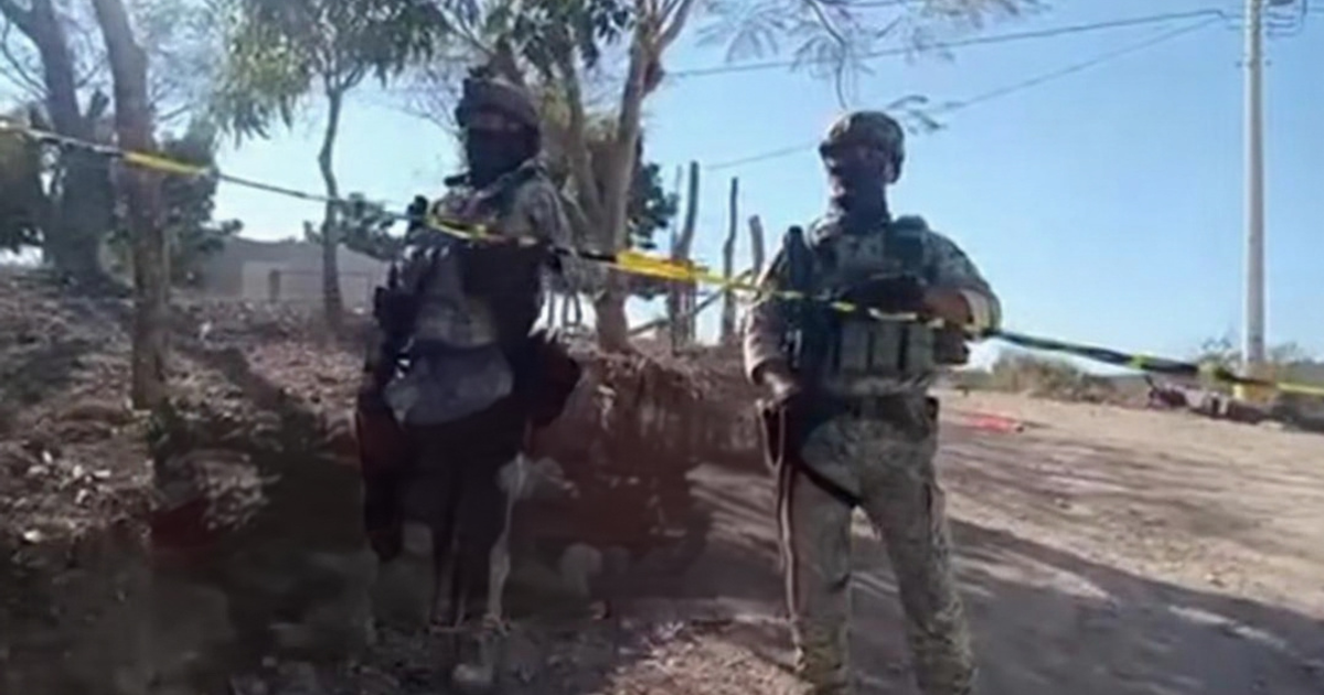 Dos soldados junto a una cinta de seguridad en un operativo militar post-persecución en Sinaloa.