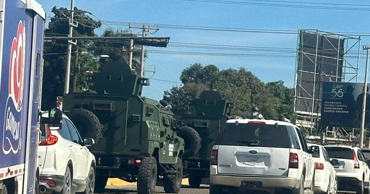 Convoy de vehículos militares verdes en Guasave durante operativo de seguridad, con entorno urbano visible.