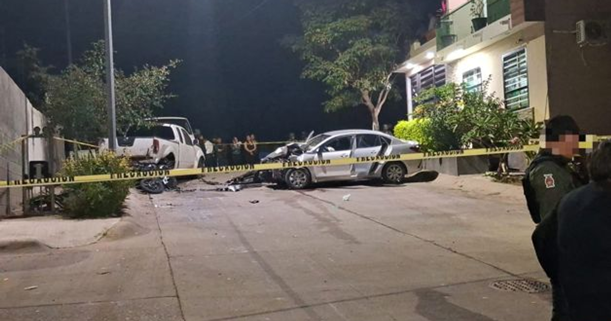 Escena nocturna de accidente en Mazatlán con coches involucrados y cinta de advertencia rodeándola, relacionado con persecución y disparos.