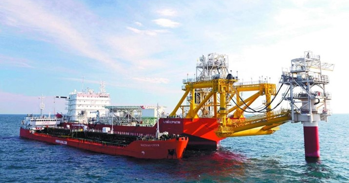 Buque tanker conectado a plataforma offshore en el agua con cielo nublado