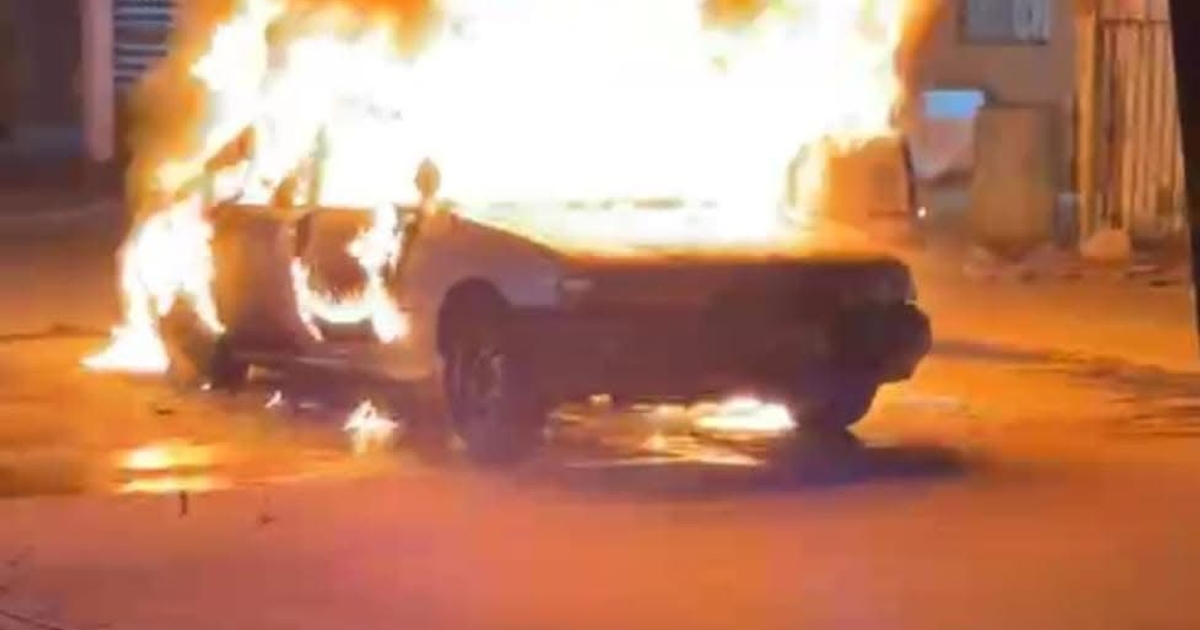 Coche en llamas estacionado en una calle de Ahome, Sinaloa, con fuego extendiéndose por toda su estructura.