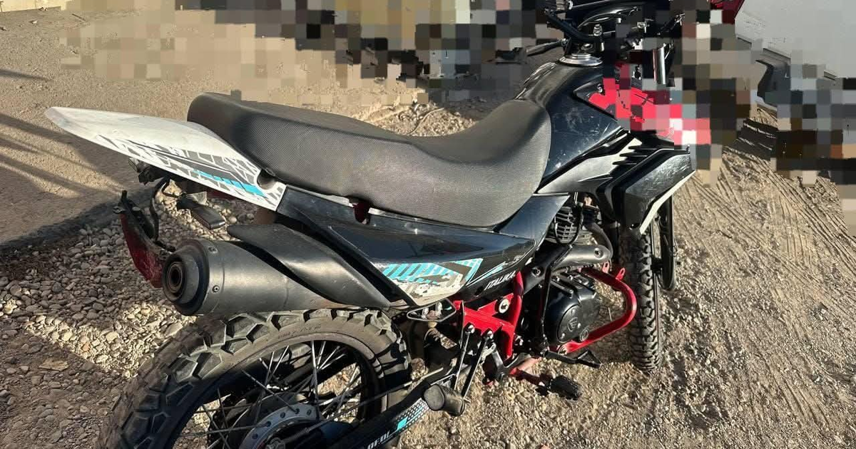 Motocicleta Italika negro con rojo en zona rocosa