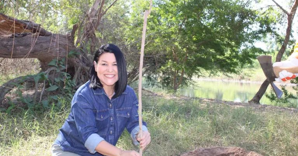 Mujer sonriente con herramienta frente a paisaje natural de Choix, Sinaloa