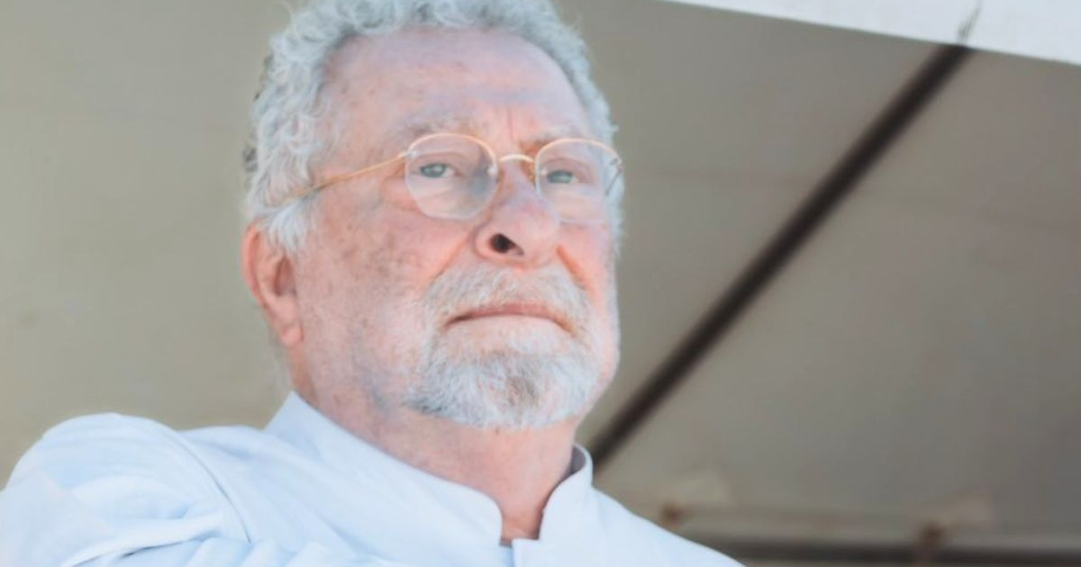 Hombre de cabello canoso y barba con lentes en un entorno exterior, posiblemente relacionado al arresto del rector en Campeche.