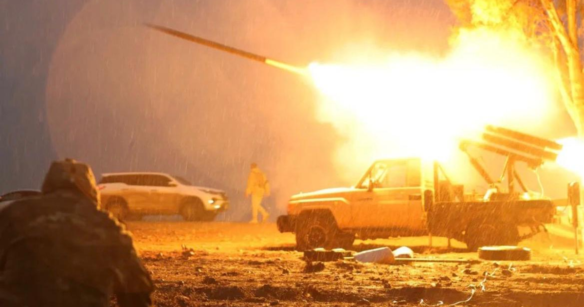 Vehículo militar lanzando proyectil con explosión en cielo, escena de conflicto