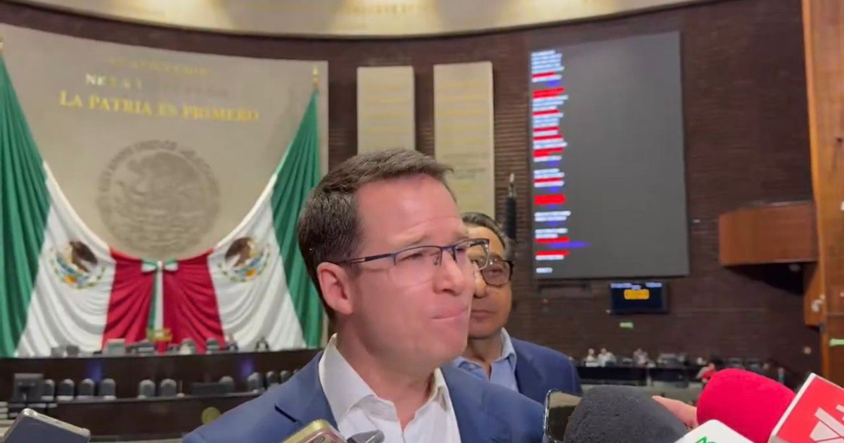 Ricardo Anaya hablando en un recinto legislativo, con banderas mexicanas detrás.