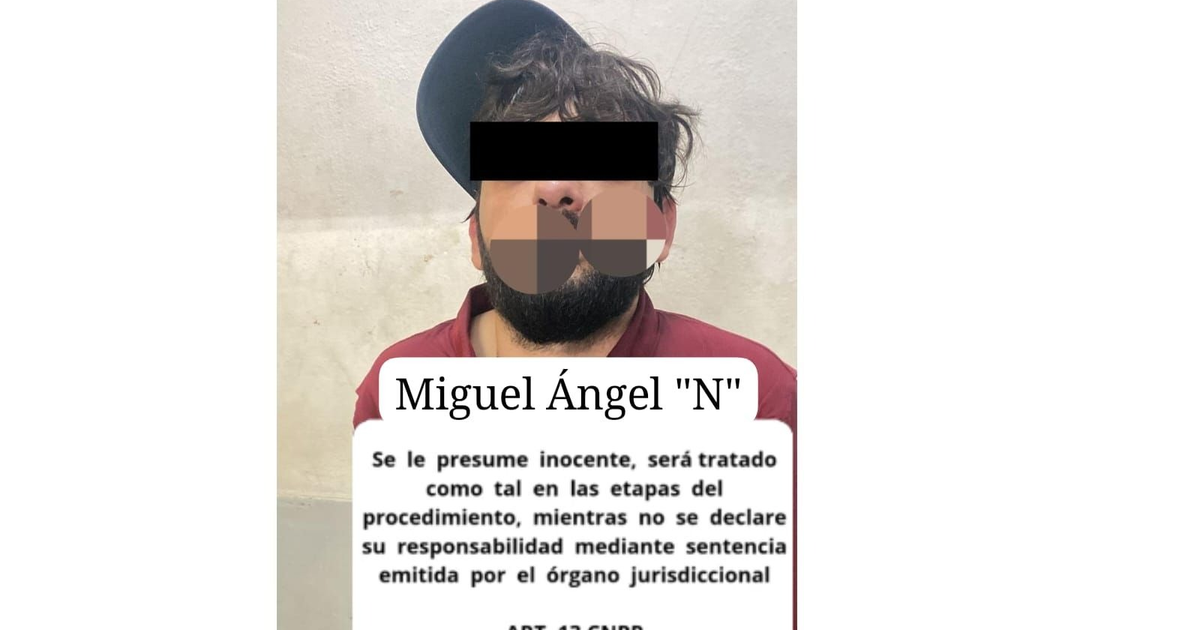Hombre con camiseta roja y gorro detenido en Mazatlán por supuesto robo. Muestra elementos de una estación policial.