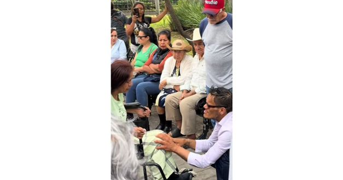 Personas interactuando en la Plaza de la República en Mazatlán, con un hombre hablando con una mujer en silla de ruedas.