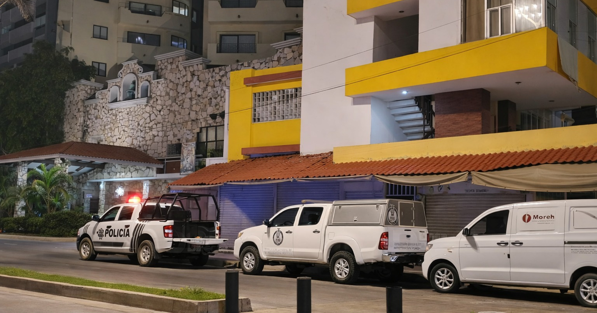 Calle nocturna en Mazatlán con camioneta de policía y vehículos estacionados