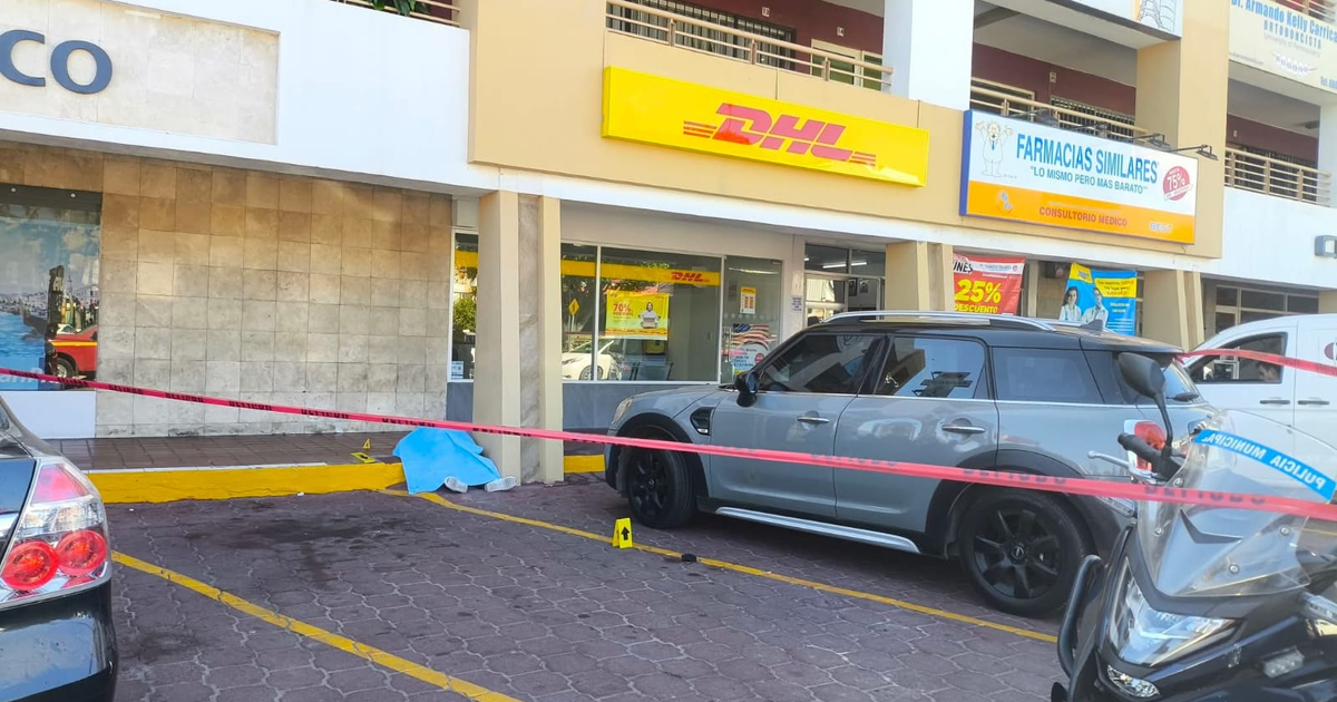 Vehículo gris rodeado por cinta policial y bulto cubierto por manta azul en incidente de Mazatlán
