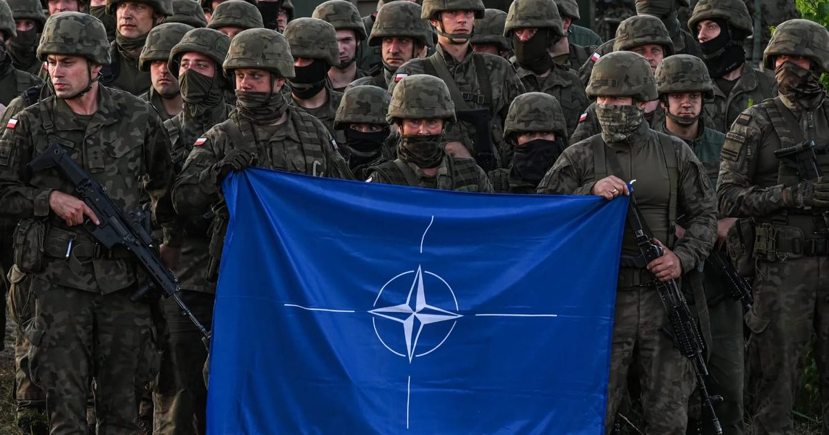 Soldados con uniformes de camuflaje sosteniendo bandera de la OTAN