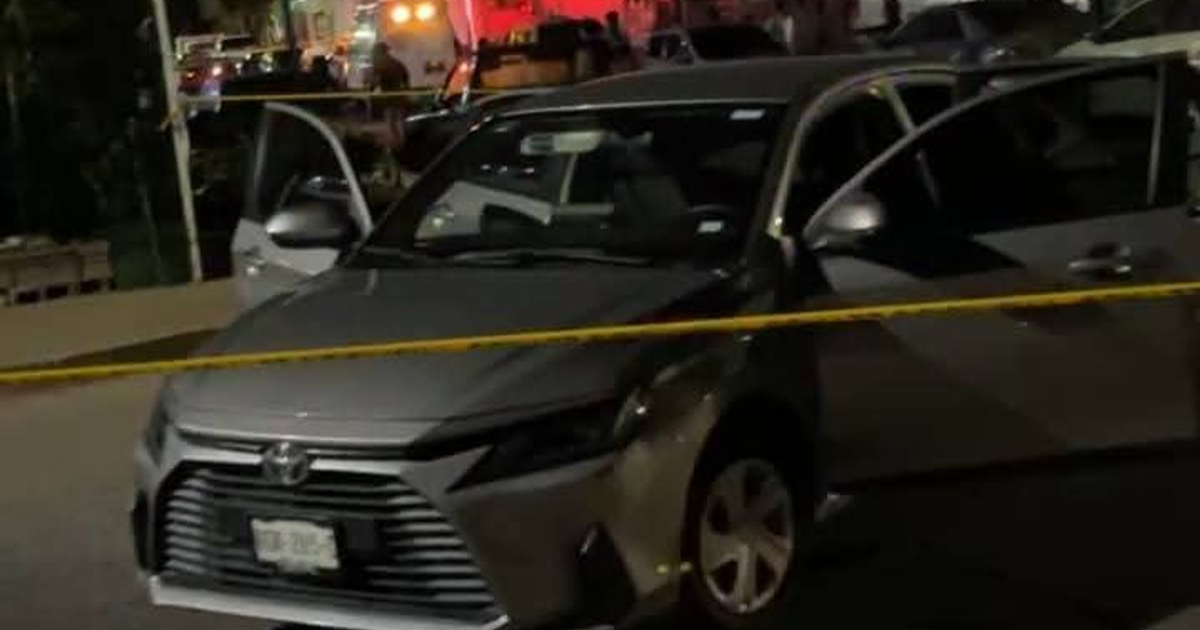 Automóvil gris con puertas abiertas rodeado por cinta amarilla en escena del crimen en Culiacán