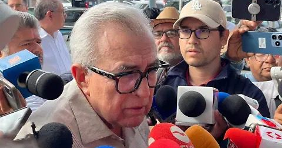 El gobernador de Sinaloa, Rubén Rocha Moya, en conferencia de prensa, rodeado de micrófonos y medios.