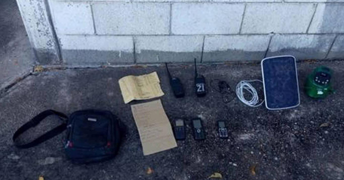 Equipamiento decomisado en Culiacán, incluyendo radios y teléfonos sobre suelo de concreto.