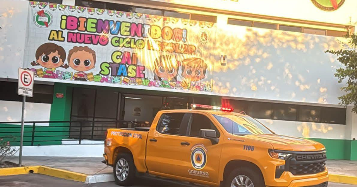 Cartel de bienvenida al nuevo ciclo escolar con camioneta de Protección Civil frente a la escuela en Culiacán, Sinaloa.
