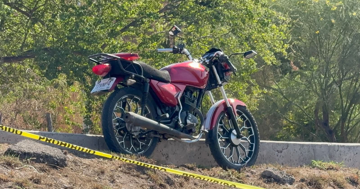 Motocicleta roja cercada con cinta amarilla 'Prohibido', vinculada a accidente fatal en Culiacán