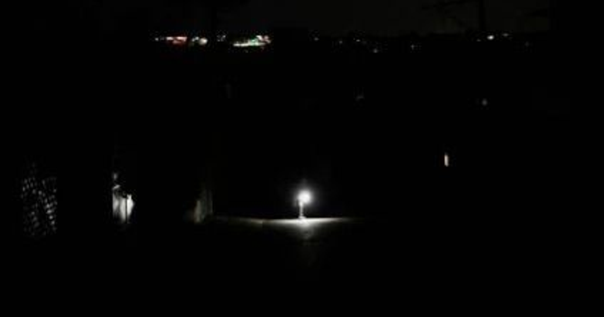 Calle oscura en La Habana con una luz encendida.