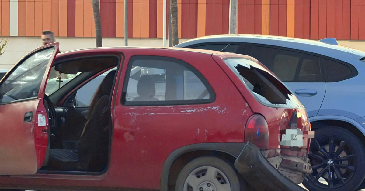 Chevy rojo dañado estacionado tras un impacto.