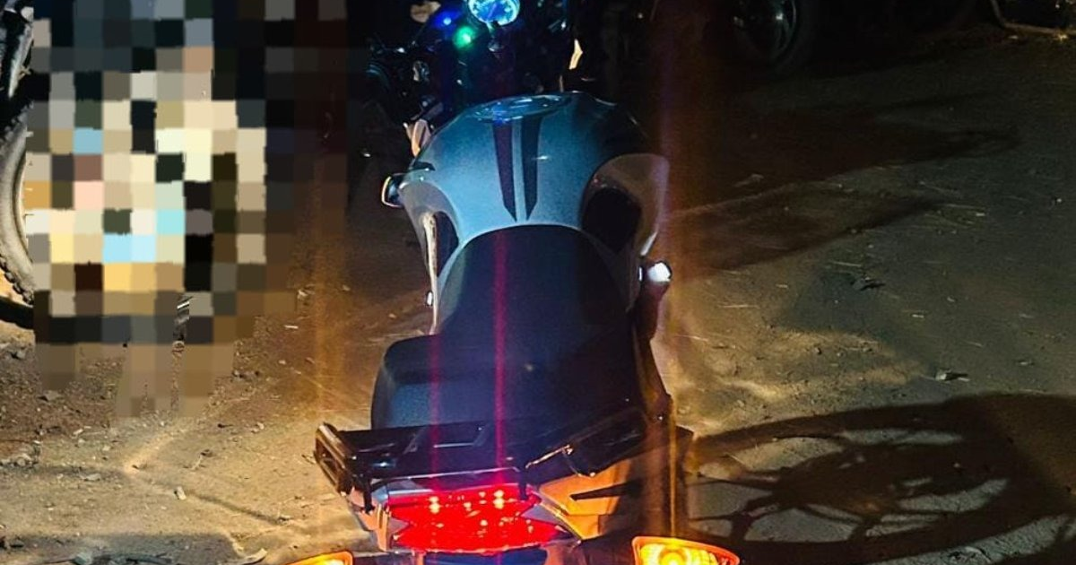 Motocicleta abandonada en la calle de noche.