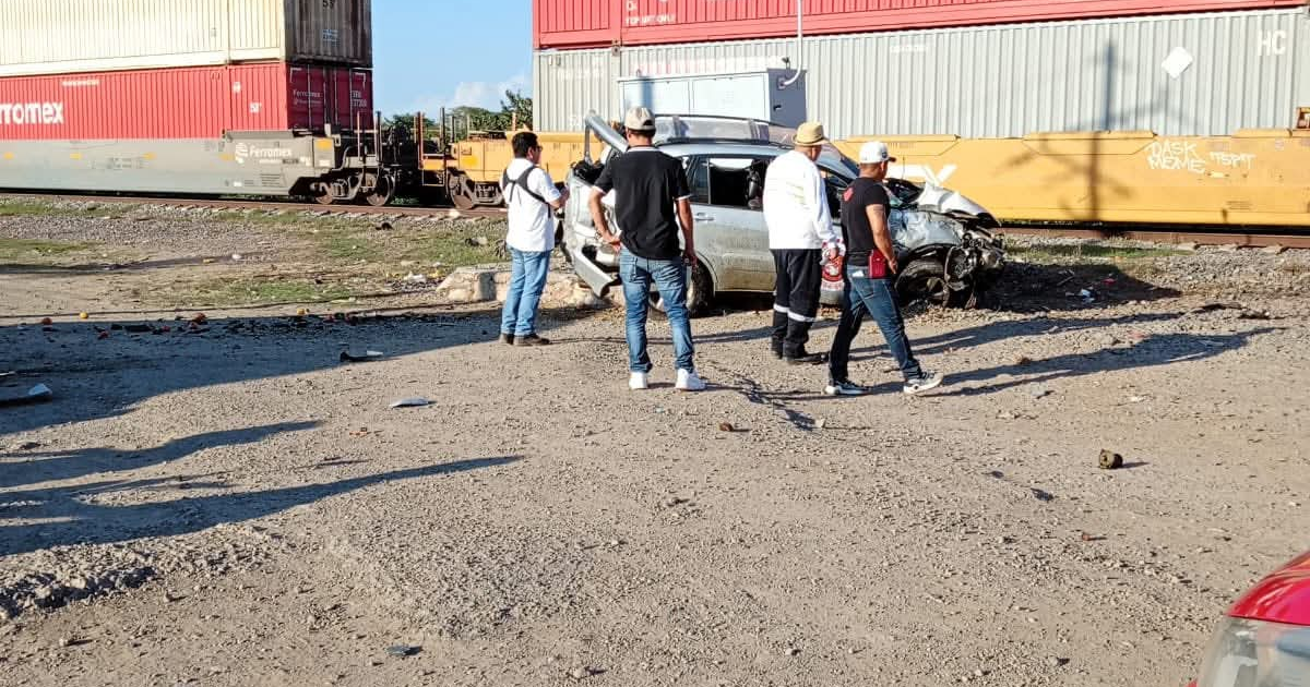Camioneta dañada junto a las vías del tren.