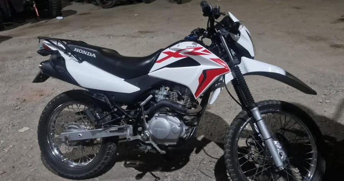 Motocicleta Honda blanca y roja estacionada.