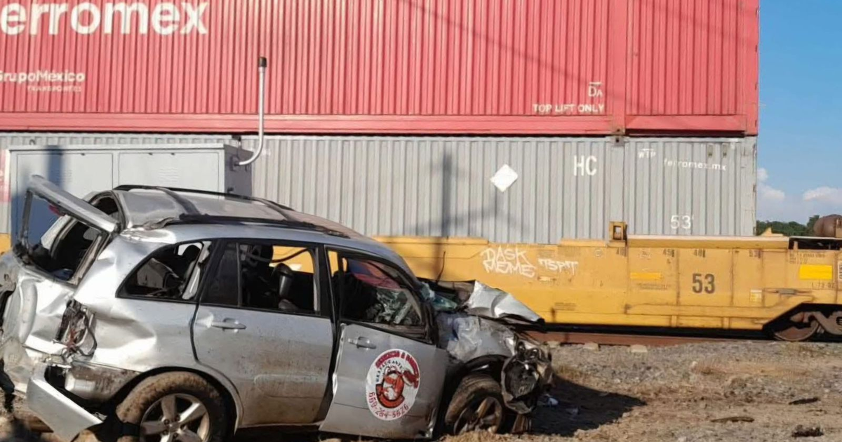 Auto dañado junto a tren tras accidente.